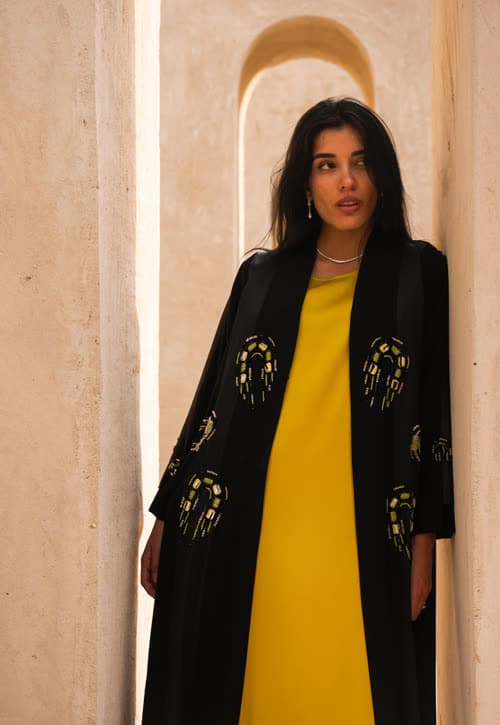 Osh campaign — black embellished coat and yellow dress