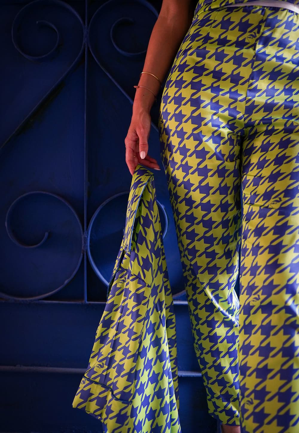 The GEM campaign — blue and yellow houndstooth trousers and matching jacket against a blue gate